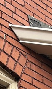 6 inch gutter cut to match the angle where the bay window meets the house